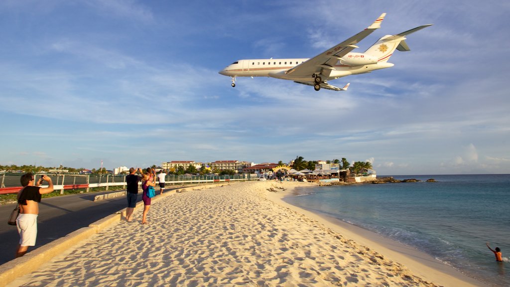 Maho Beach ofreciendo una playa de arena, una ciudad costera y aeronave