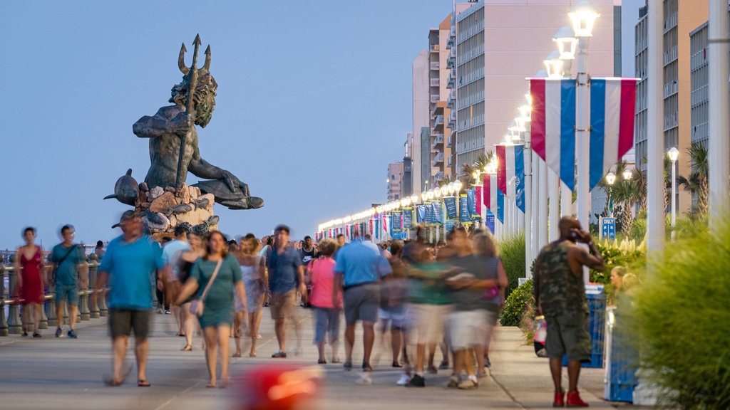 Virginia Beach Boardwalk showing a statue or sculpture, night scenes and a coastal town