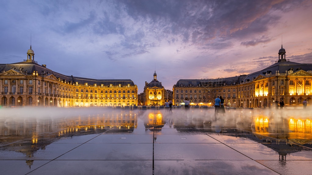 Place de la Bourse ofreciendo un parque o plaza, escenas nocturnas y una puesta de sol