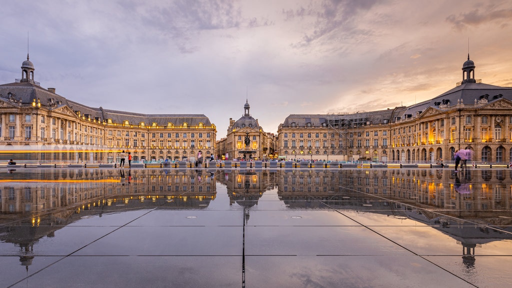 Place de la Bourse que inclui uma praça ou plaza, arquitetura de patrimônio e um pôr do sol