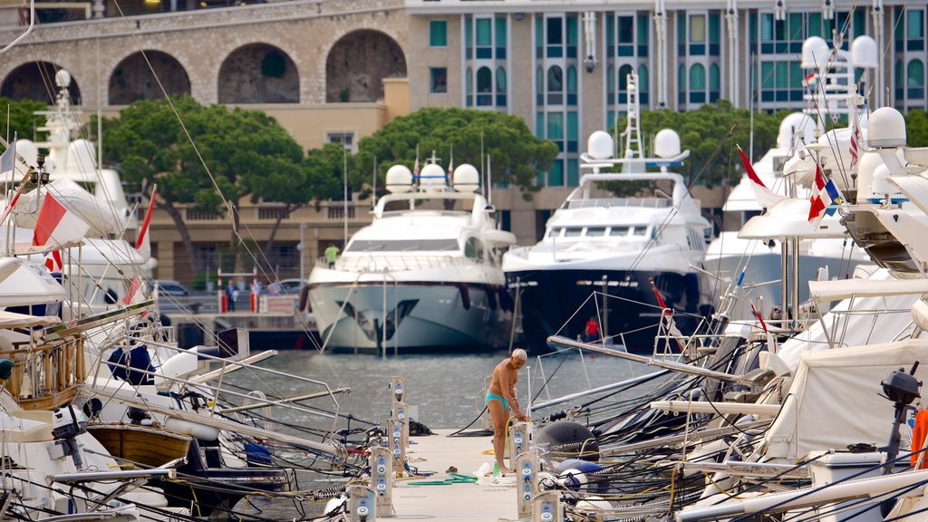 Monaco Harbour featuring a bay or harbor as well as an individual male