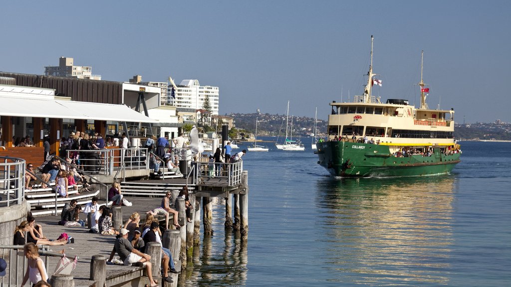 Manly Beach featuring a ferry and a marina as well as a large group of people