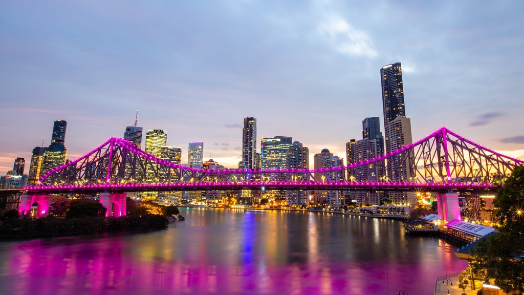 Story Bridge showing a city, a sunset and a river or creek