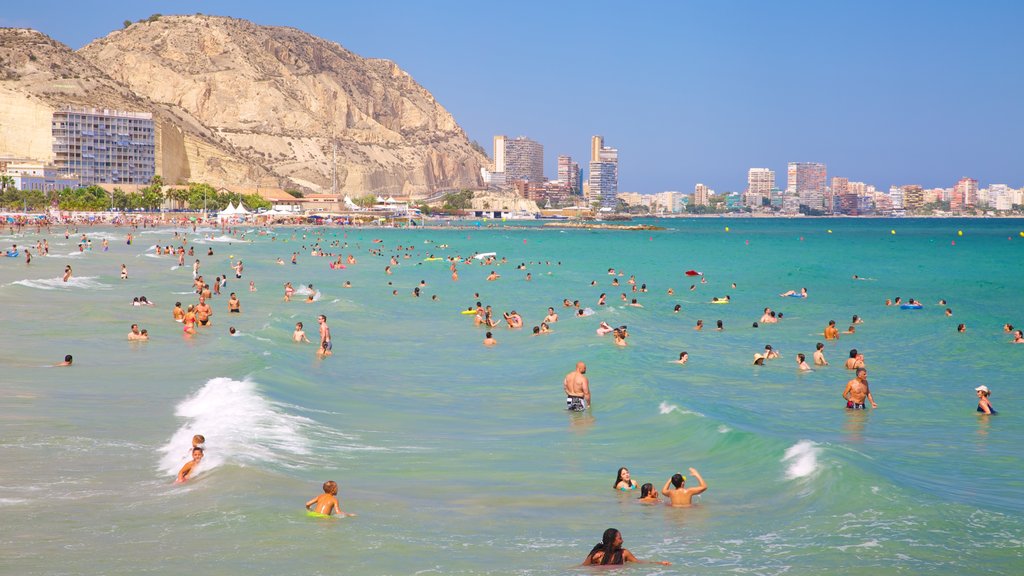 Postiguet Beach showing a coastal town, swimming and general coastal views