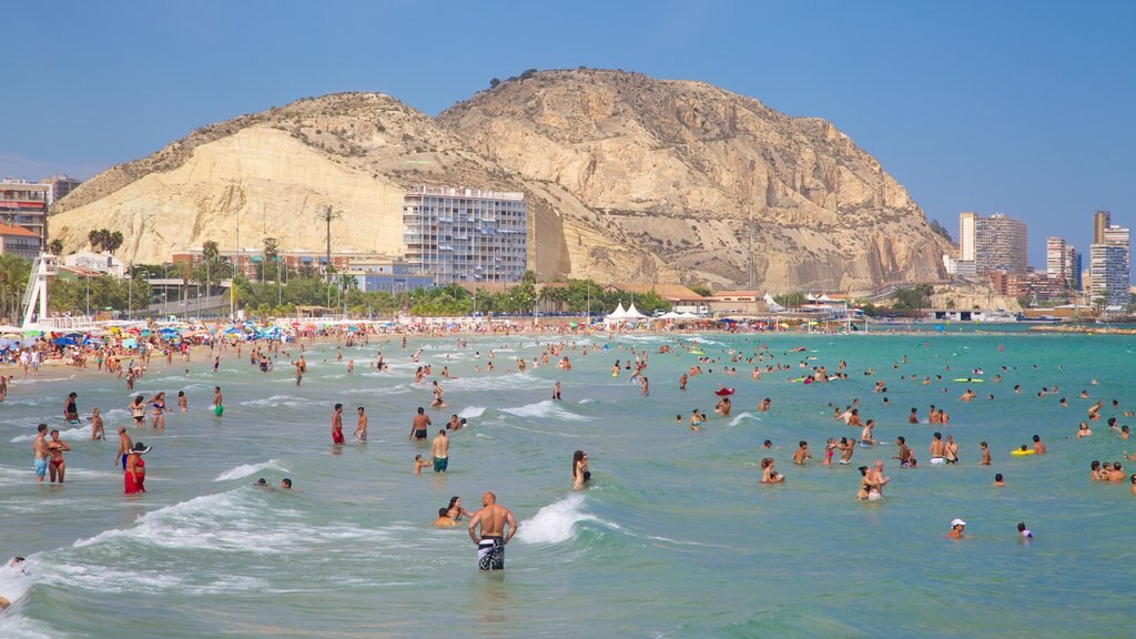 Postiguet Beach which includes mountains, a sandy beach and swimming