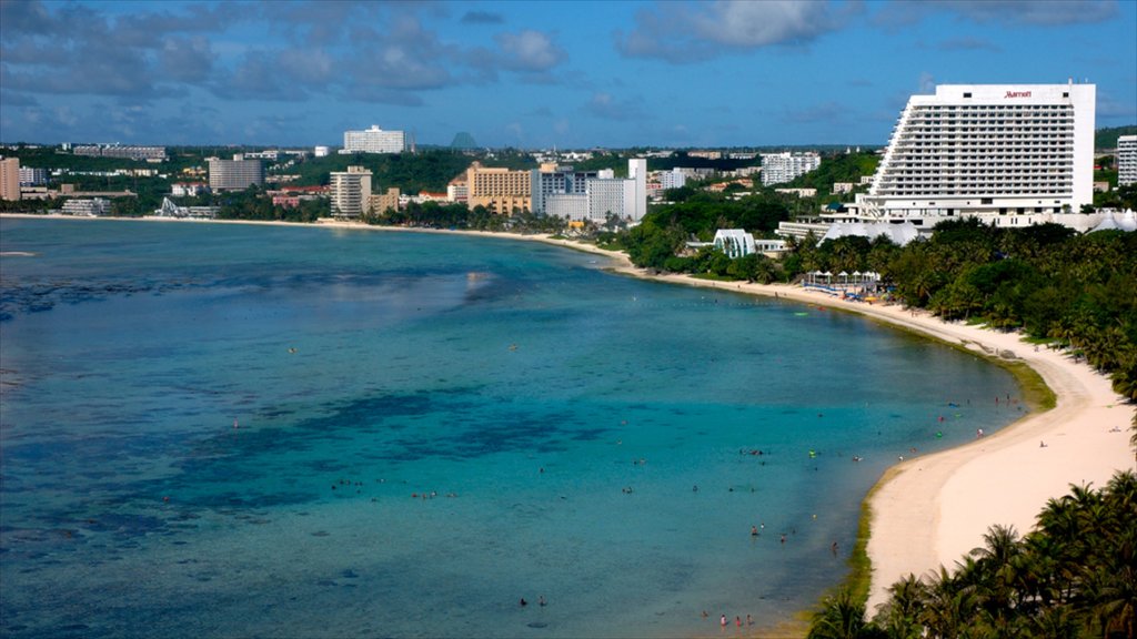 Guam ofreciendo escenas tropicales, una bahía o un puerto y una playa de arena