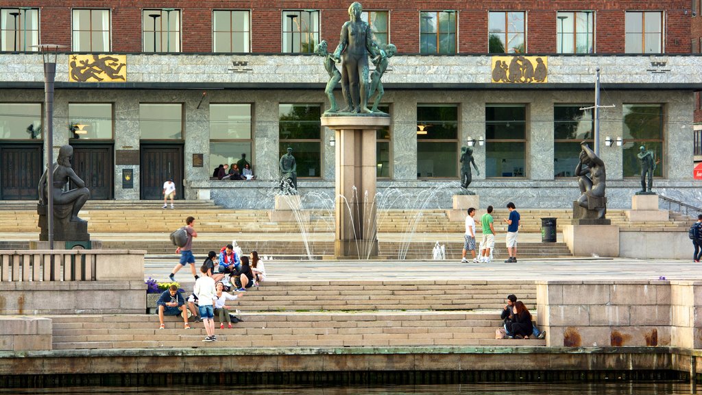 Aker Brygge showing a statue or sculpture, a fountain and a square or plaza