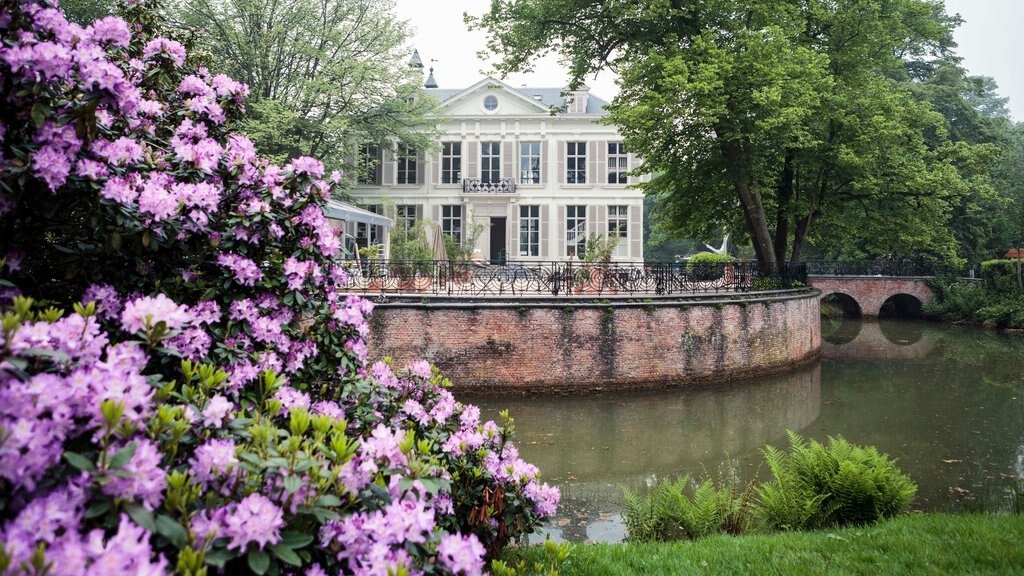 Museo de Middelheim que incluye flores, un jardín y un estanque