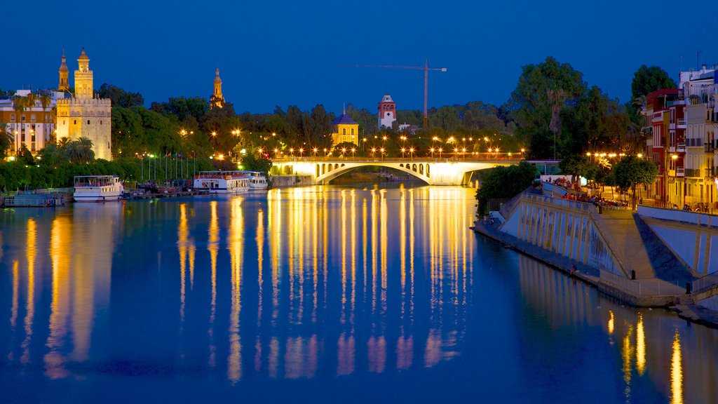 Puente de Triana mostrando escenas nocturnas, un puente y una marina