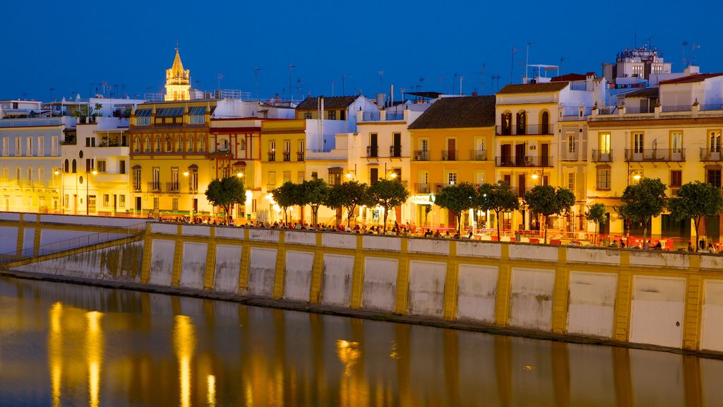 Puente de Triana que incluye una ciudad, un río o arroyo y escenas nocturnas