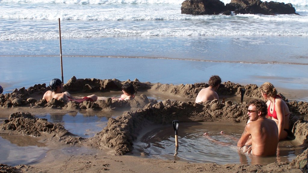 Hot Water Beach que incluye una playa de arena y natación y también un pequeño grupo de personas