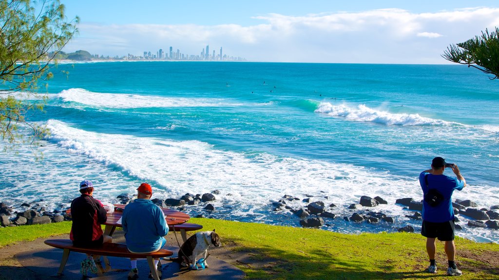 Burleigh Heads featuring rugged coastline and surf as well as a small group of people