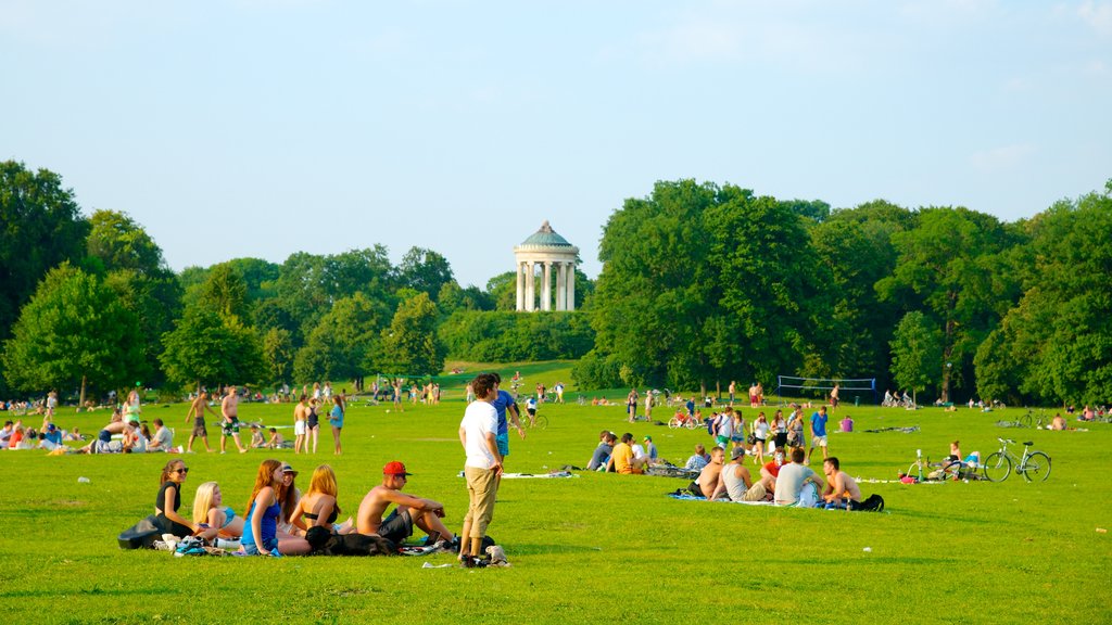 Jardín inglés ofreciendo un parque y una ciudad y también un gran grupo de personas