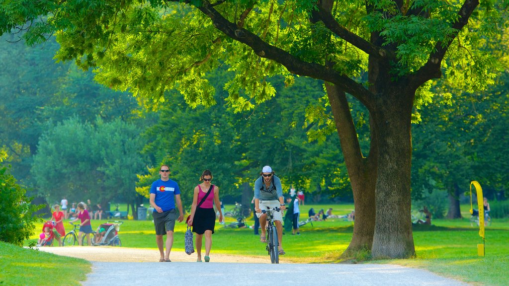 Jardín inglés que incluye ciclismo y un parque y también un gran grupo de personas