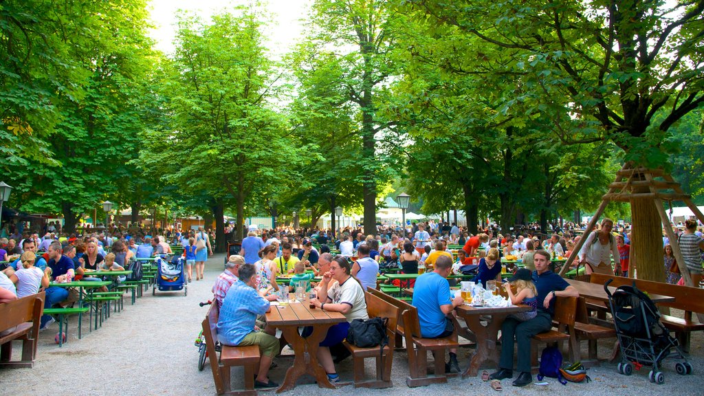 Jardín inglés mostrando jardín y comidas al aire libre y también un gran grupo de personas