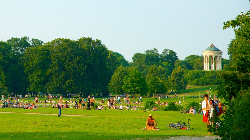 Englischer Garten mostrando um jardim e piquenique assim como um grande grupo de pessoas