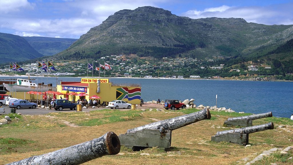 Playa Hout Bay que incluye arte al aire libre, una bahía o un puerto y montañas