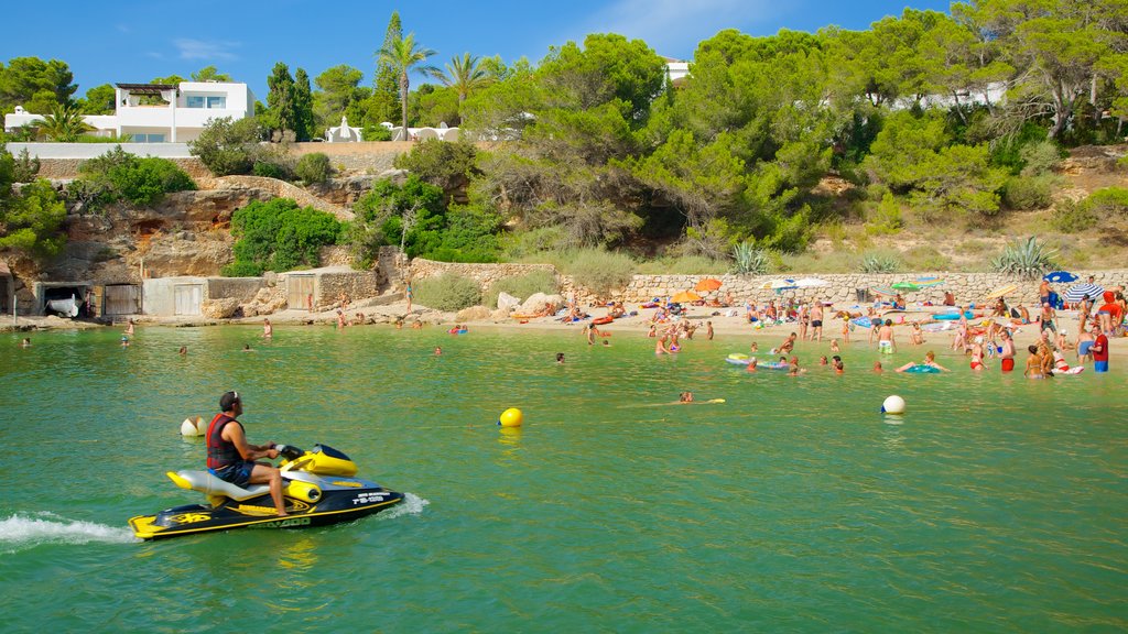 Cala Gracio featuring a sandy beach, jet skiing and a coastal town