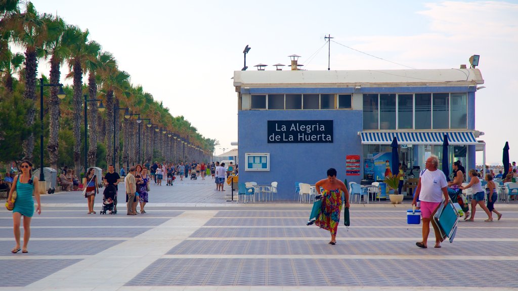 Malvarrosa Beach which includes a coastal town and street scenes as well as a large group of people