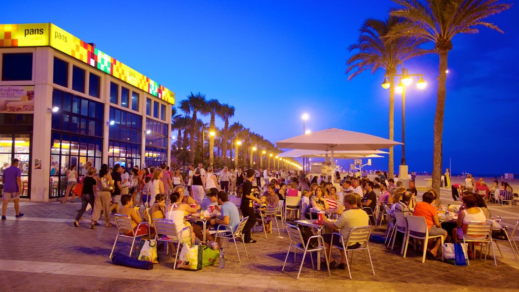 Malvarrosa Beach which includes outdoor eating, night scenes and a beach