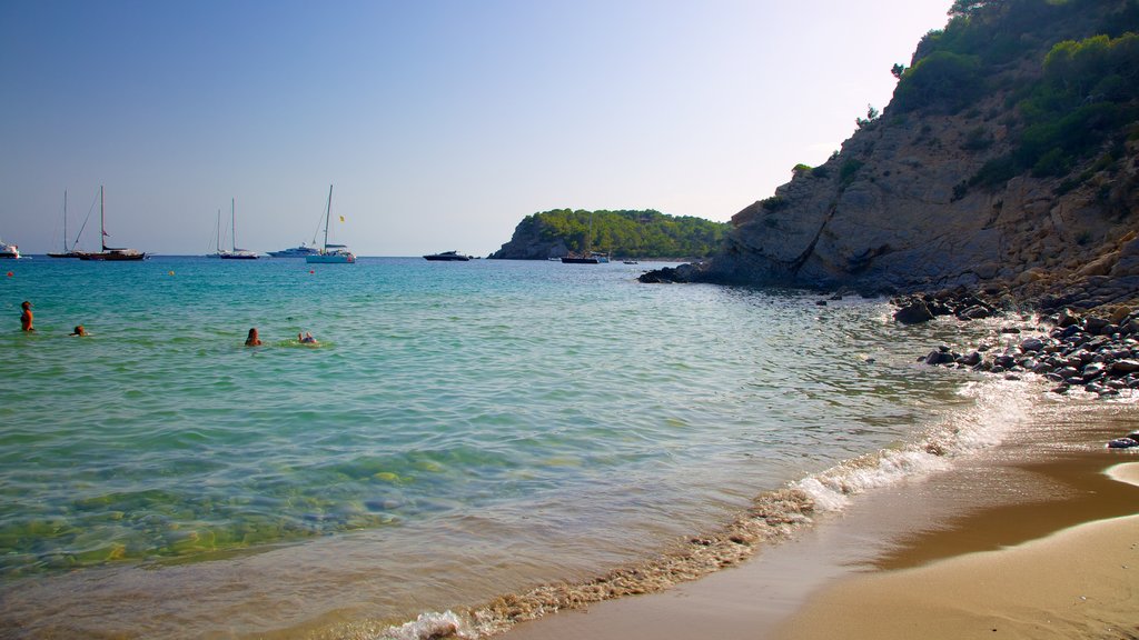 Cala Jondal Beach showing landscape views, a beach and swimming