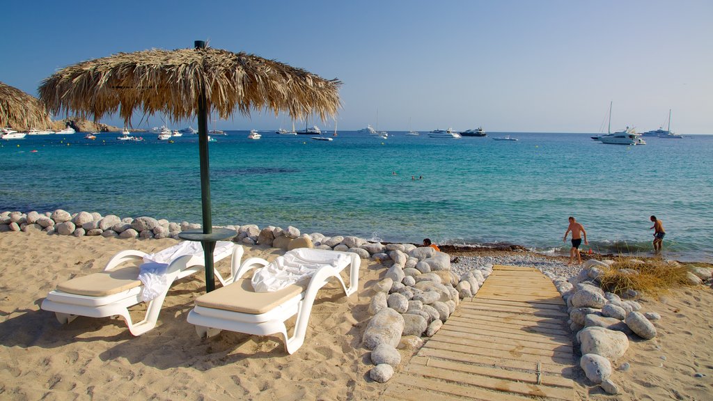 Playa de Cala Jondal mostrando escenas tropicales, una playa de arena y botes