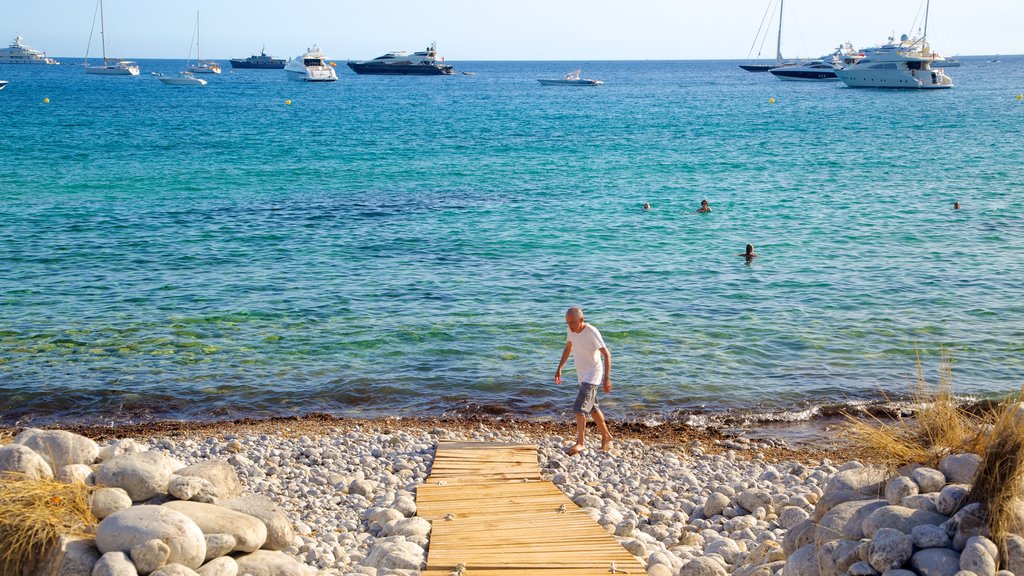 Cala Jondals strand som inkluderar en stenstrand och båtkörning såväl som en man