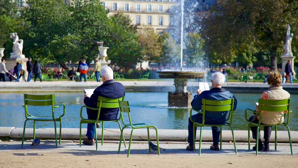 Der Louvre in Paris welches beinhaltet Springbrunnen sowie kleine Menschengruppe