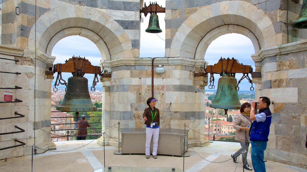 Torre Inclinada de Pisa caracterizando arquitetura de patrimônio e paisagens assim como um pequeno grupo de pessoas