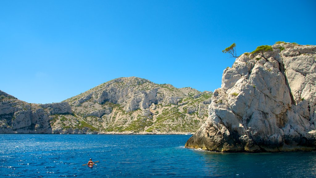 Calanques que incluye montañas, costa escarpada y kayaks o canoas