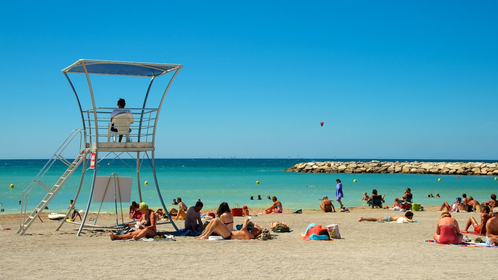 Prado-stranden som viser sandstrand og kyst i tillegg til en stor gruppe med mennesker