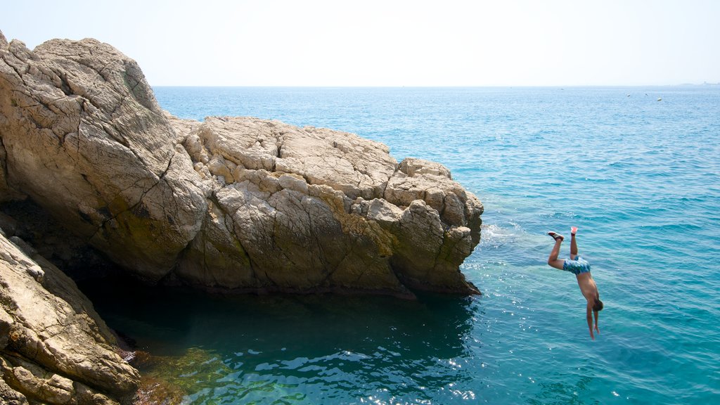 Nizza che include costa rocciosa e nuoto cosi come ragazzo