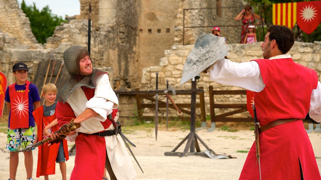 Chateau des Baux which includes performance art and château or palace as well as a small group of people