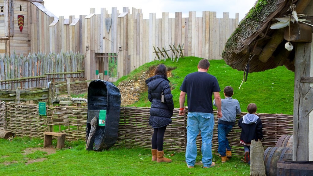 Mountfitchet Castle ofreciendo un castillo y elementos patrimoniales y también una familia