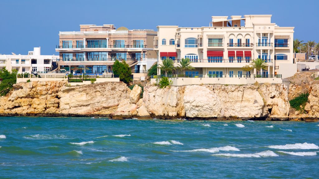 Shatti Al Qurum showing rocky coastline and a coastal town