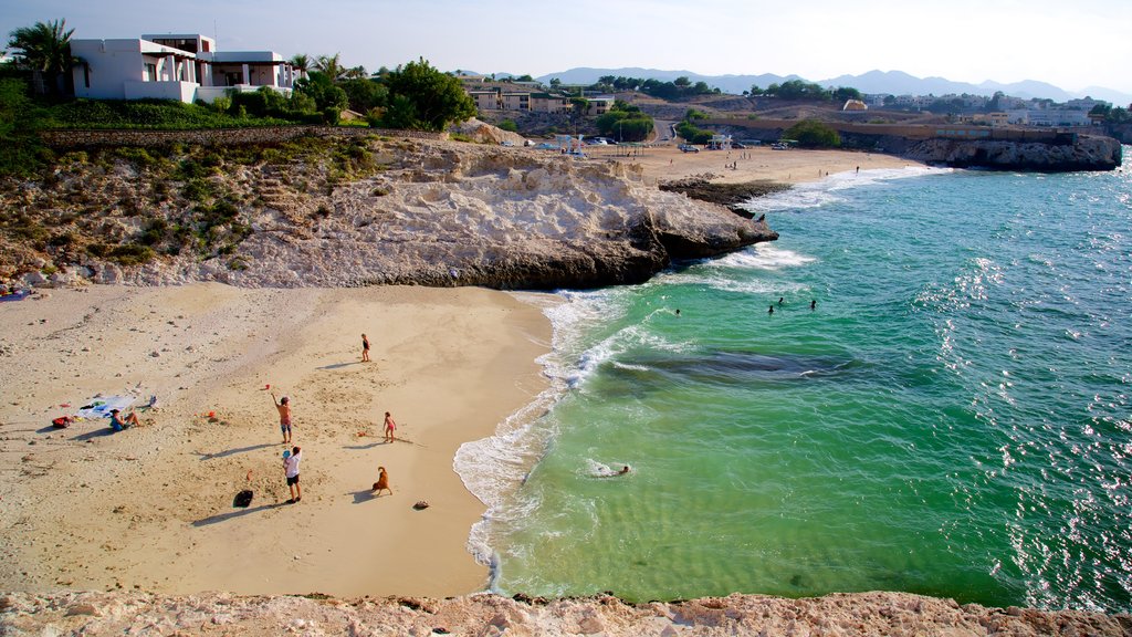 Shatti Al Qurum showing rugged coastline, a beach and general coastal views