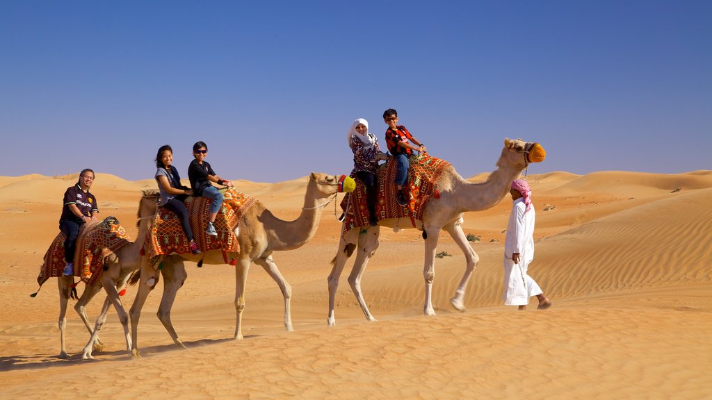 Dubain aavikko johon kuuluu autiomaanäkymät ja maaeläimet sekä pieni ryhmä ihmisiä