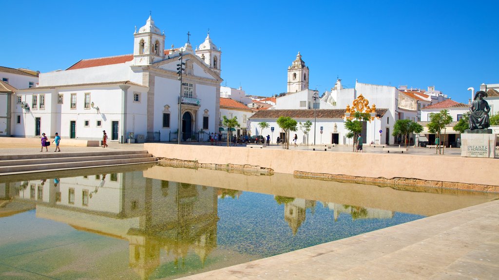 Algarve ofreciendo una pequeña ciudad o aldea, una iglesia o catedral y piscina