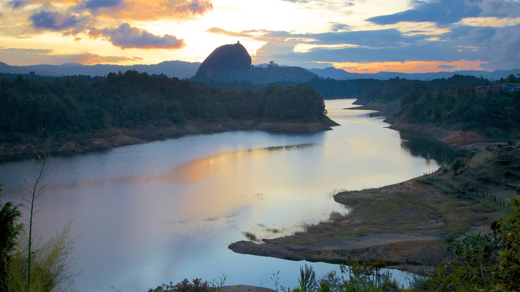 Roca de Guatapé que incluye imágenes de bosques, escenas tranquilas y un atardecer