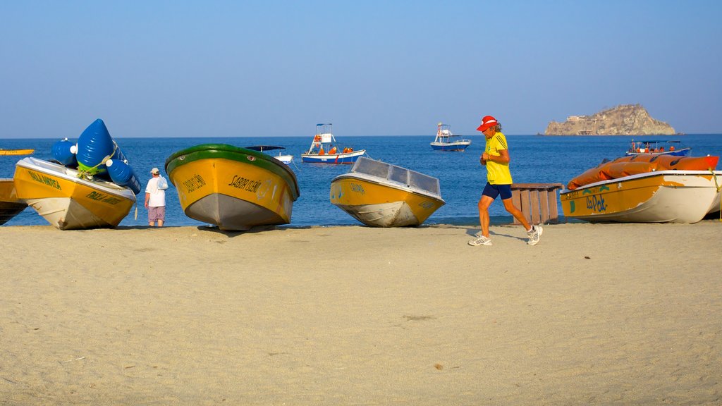 Rodadero Beach featuring boating and a sandy beach as well as an individual male