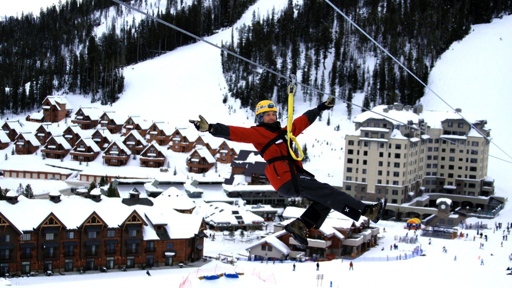 Estación de esquí Big Sky Resort mostrando nieve, tirolesa y una pequeña ciudad o pueblo