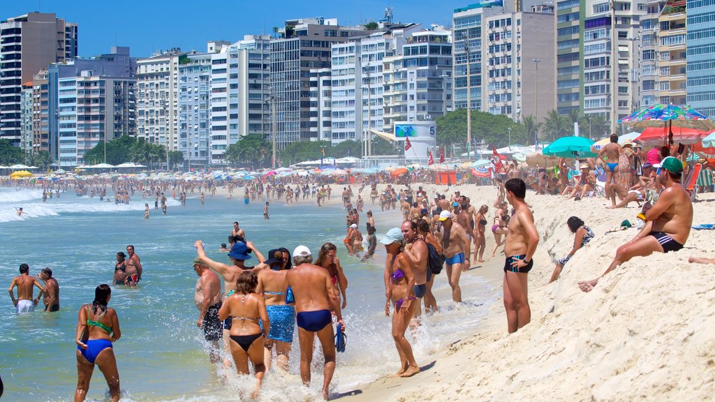 Copacabana Beach which includes a sandy beach as well as a large group of people