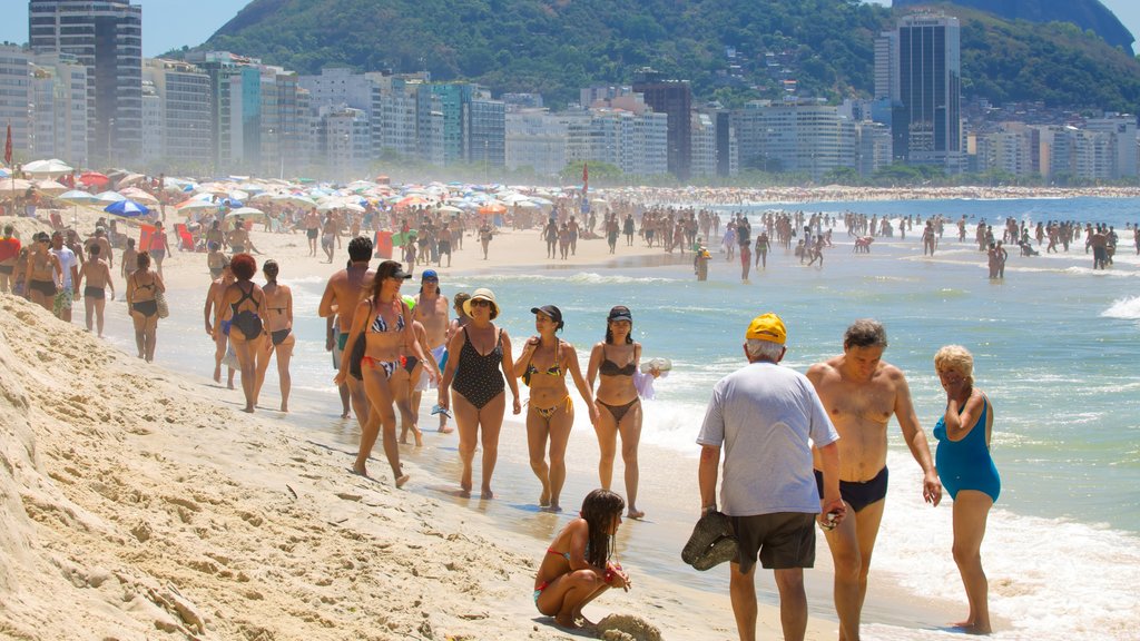 Copacabana Beach som omfatter svømning og en strand såvel som en stor gruppe mennesker