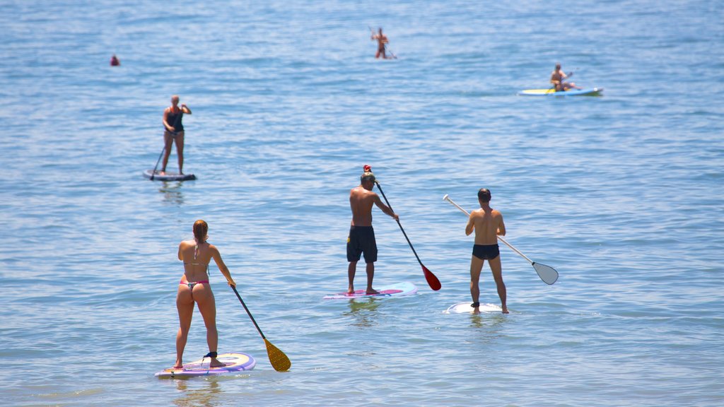 Praia de Copacabana que inclui paisagens litorâneas e esportes aquáticos assim como um pequeno grupo de pessoas