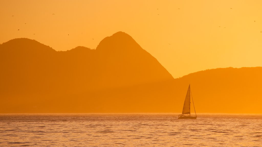 Playa de Copacabana que incluye vistas generales de la costa, una puesta de sol y navegación