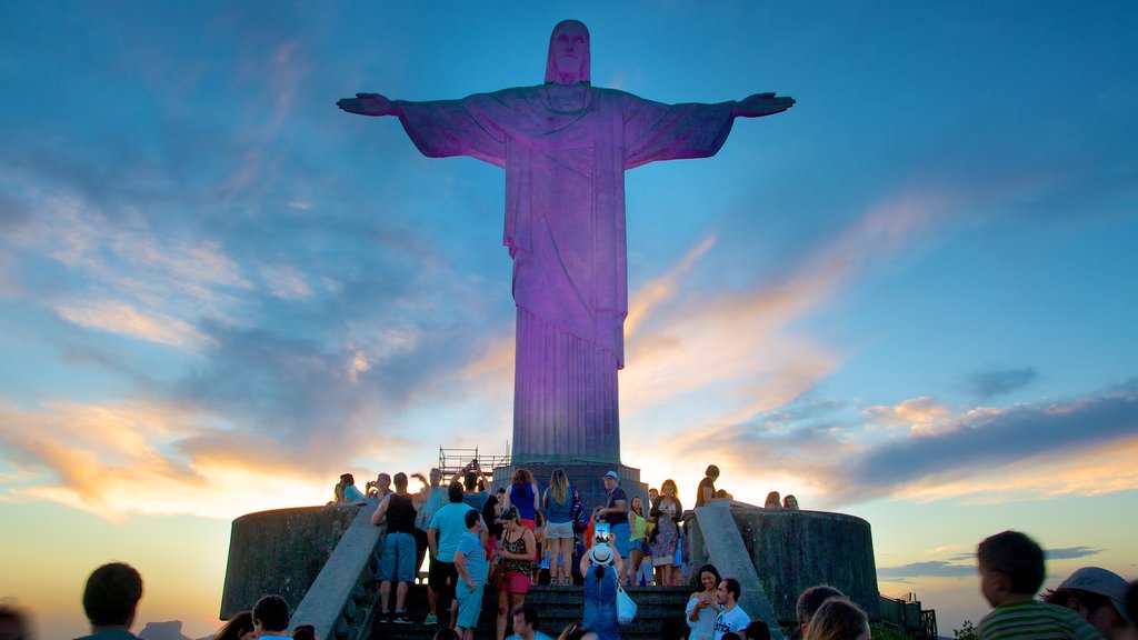 Cristo de Corcovado mostrando elementos religiosos, una estatua o escultura y un atardecer