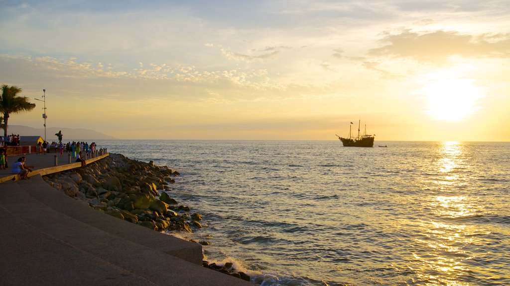 Malecón que incluye un atardecer y costa rocosa