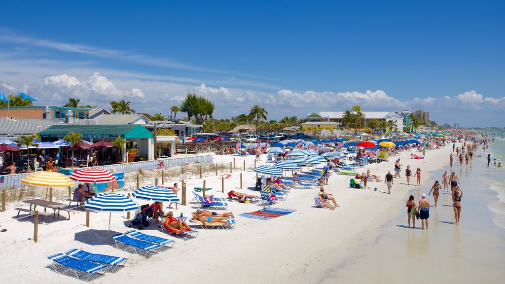 Fort Myers Beach mostrando um hotel de luxo ou resort e uma praia assim como um grande grupo de pessoas