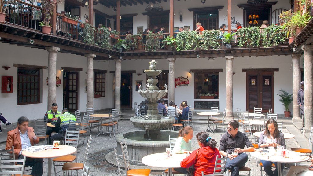 Palácio de Carondelet caracterizando estilo de vida de cafeteria e uma fonte assim como um grande grupo de pessoas