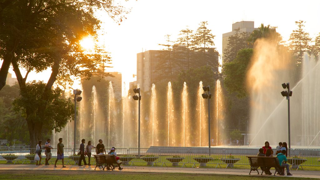 Parque de Exposiciones que incluye jardín y una fuente y también un gran grupo de personas